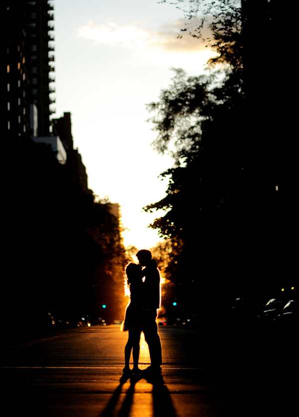 happy couple silhouetted in the late evening sunset - standing in the middle of the street -  photo by New York City based wedding photographer Ryan Brenizer